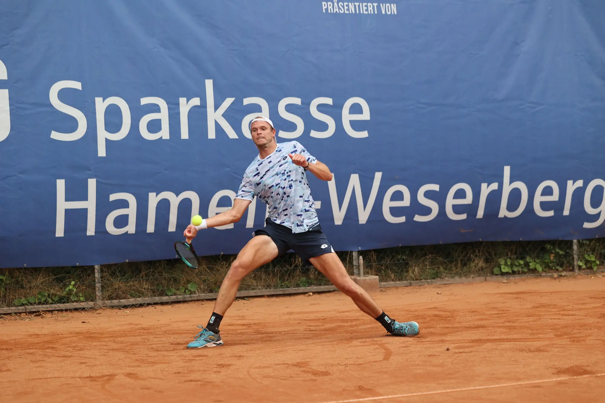Spieler im Ausfallschritt auf dem Sandplatz