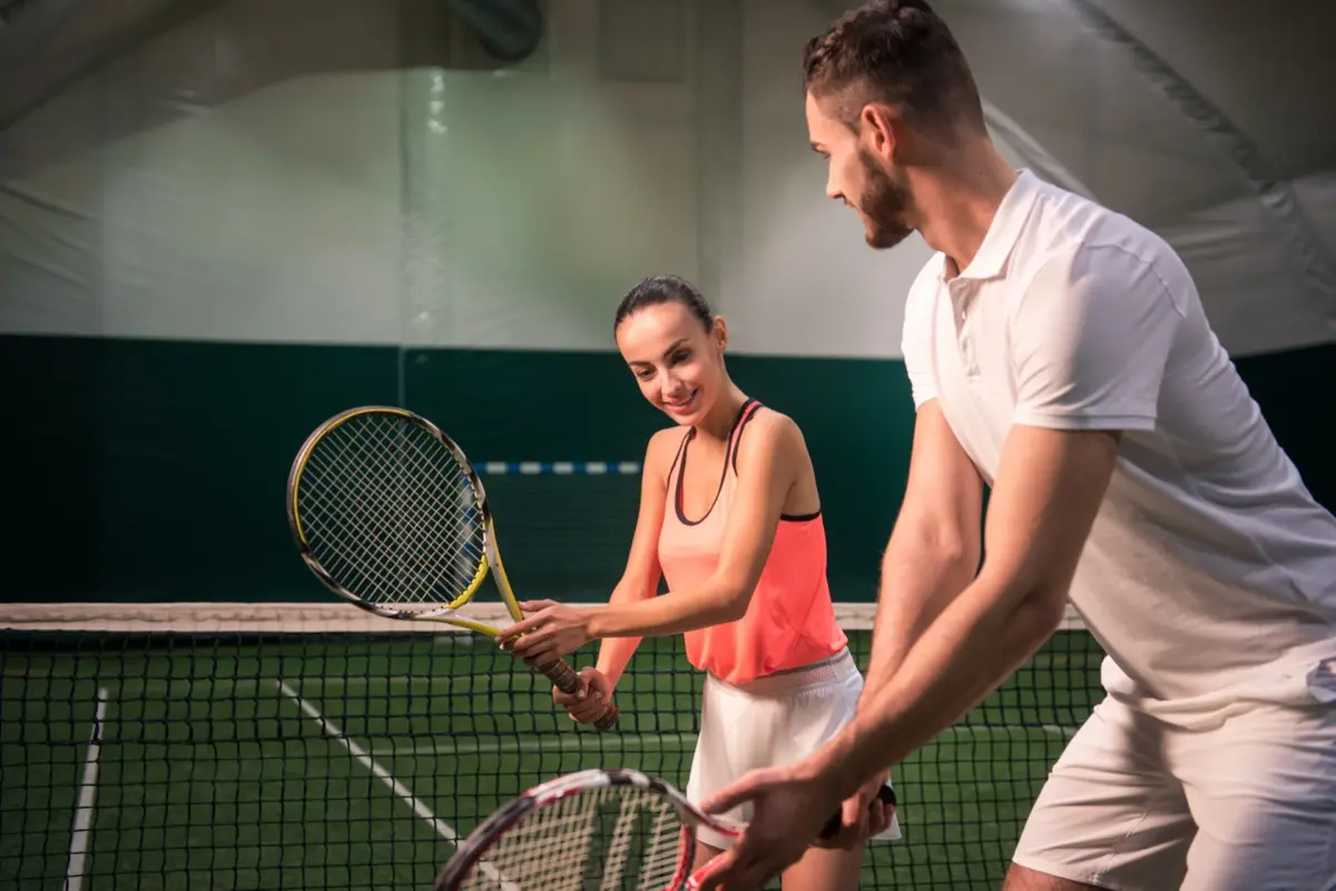 Trainer erklärt einer Spielerin beim Probetraining den Schlag