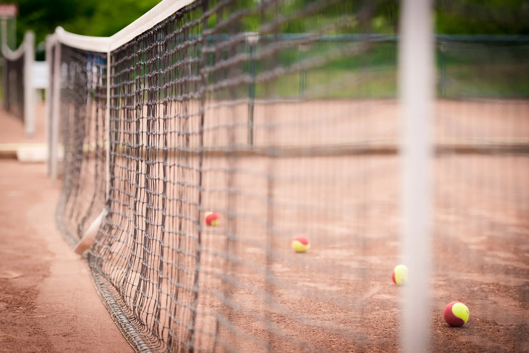 Tennisnetz mit Bällen auf dem Sandplatz